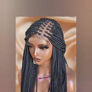 May include: A black braided wig with a lace front. The wig features small, neatly arranged braids throughout, with a patterned design on top. The wig is styled on a mannequin head, showcasing the hairline and overall look.