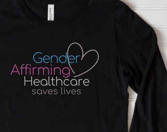 May include: Black long-sleeve shirt with the text "Gender Affirming Healthcare saves lives" and a pink heart graphic.