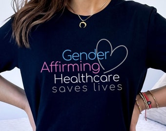May include: A black t-shirt with the text "Gender Affirming Healthcare saves lives" in pink, blue, and gray lettering. A stylized heart is included in the design.