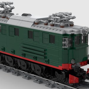 Puede incluir: Un modelo detallado de locomotora de tren en verde oscuro, gris y rojo. El tren presenta detalles intrincados, incluido el equipo eléctrico aéreo y un tren de rodaje detallado con ruedas. El modelo está sobre una vía gris sobre un fondo blanco.