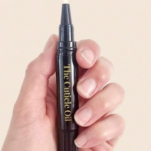May include: A black cuticle oil pen with a white applicator tip. The pen has gold lettering that reads "The Cuticle Oil".