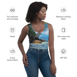 May include: A fitted tank top with a tropical beach scene print. The tank top is made of 4-way stretch fabric and is moisture-wicking. It also has a tear-away care label and offers UPF 50+ sun protection.