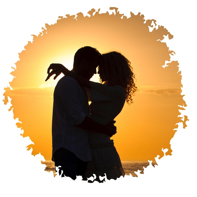 May include: Silhouette of a couple embracing at sunset, with the sun setting behind them. The couple is standing on a beach with the ocean in the background.