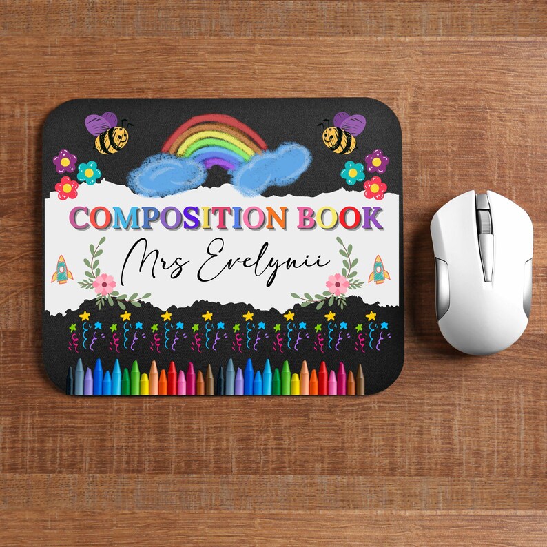 Pode incluir: Tapete de rato preto com um design colorido com arco-&iacute;ris, nuvens, abelhas, flores e uma fileira de l&aacute;pis de cor. O texto "COMPOSITION BOOK Mrs. Evelynii" &eacute; exibido. Um rato de computador branco est&aacute; ao lado.