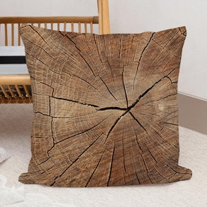 May include: A brown throw pillow with a wood grain pattern that resembles a tree stump.