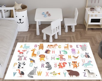 May include: A white rectangular rug with the alphabet and animal illustrations. The rug features colorful letters and cartoon animals like a giraffe, lion, and zebra. A white table and chairs are in the background.