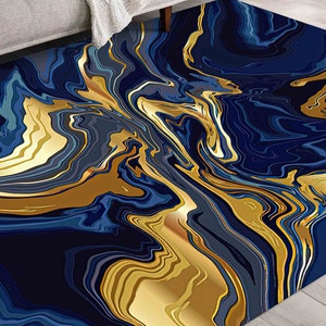 Peut inclure: Tapis de salon abstrait avec un motif tourbillonnant de bleu et d'or. Le tapis a un design moderne et contemporain.