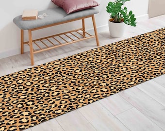 Könnte beinhalten: Ein brauner und schwarzer Leopardenfell-Teppich mit hellbraunem Hintergrund. Der Teppich liegt auf einem hellen Holzboden.
