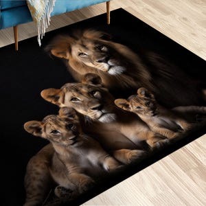 May include: A rectangular black rug featuring a family of lions. The image shows a male lion, a lioness, and two cubs. The lions are in shades of brown and tan, with detailed fur textures. The rug is suitable for a living room or bedroom.