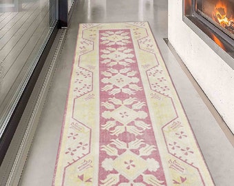 Könnte beinhalten: Ein rosafarbener und cremefarbener Läufer mit geometrischem Muster. Der Läufer hat ein florales Muster mit einem zentralen Motiv aus stilisierten Tulpen.