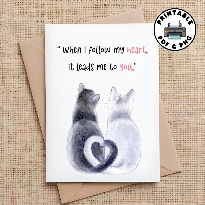 May include: A printable card with two cats sitting back to back. The cat on the left is gray and the cat on the right is white. Their tails form a heart shape. The card reads "when I follow my heart, it leads me to you."