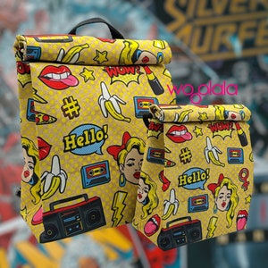 May include: Two yellow lunch bags with a pop art design featuring lips, bananas, cassette tapes, and the words "Hello!" and "Wow!" The bags have black handles and a fold-over top.