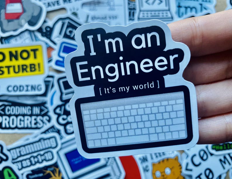 Może przedstawiać: Czarno-biała naklejka z tekstem "I'm an Engineer [It's my world]" i grafiką klawiatury. Naklejka znajduje się na dłoni.