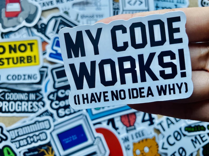 Może przedstawiać: Biała naklejka z czarnym tekstem, kt&oacute;ry brzmi "My Code Works! (I Have No Idea Why)". Naklejkę trzyma ręka.