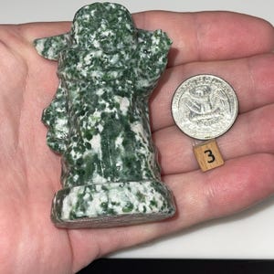 Carved crystal art: jadeite wise being and green dot jasper infant alien. Meditation tools, office accessories, and unique gifts. Natural stone figurines.