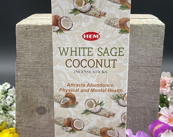 May include: A box of HEM White Sage Coconut incense sticks. The box is white with a brown and white floral pattern. The text on the box reads "HEM White Sage Coconut Incense Sticks" and "Attracts Abundance, Physical and Mental Health".