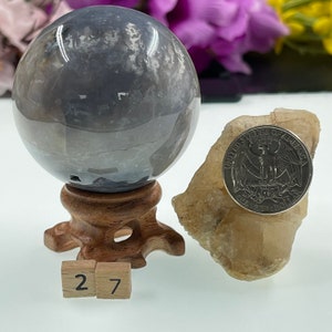 May include: A grey and white agate sphere on a wooden stand with a US quarter for scale. The sphere is approximately 2.7 inches in diameter.