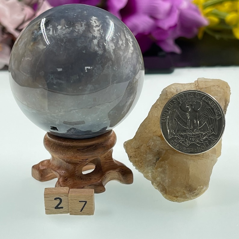 May include: A grey and white agate sphere on a wooden stand with a US quarter for scale. The sphere is approximately 2.7 inches in diameter.
