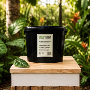 Könnte beinhalten: Ein schwarzer Kunststoffeimer mit 10L Greensoils Advanced Substrates Dschungelboden-Mix. Das Etikett enthält den Text Wasserspeicher, luftige Struktur und Schwarzfaser sowie einen Barcode. Ein einzelnes grünes Blatt liegt neben dem Eimer.