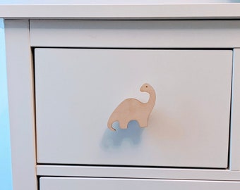 May include: White chest of drawers with a wooden dinosaur-shaped drawer pull.