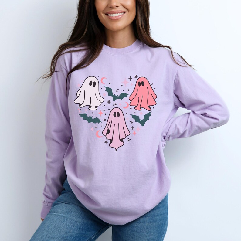 T-shirt with a heart-shaped design featuring three ghosts in pink and white with bats and stars.