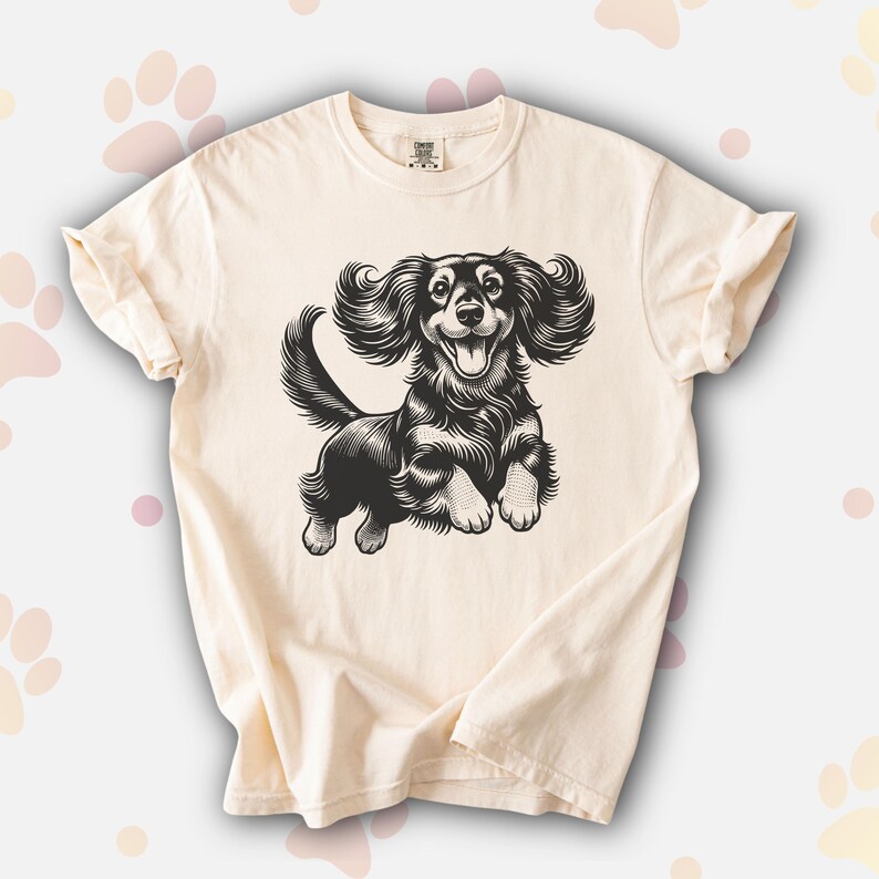 Comfort colors premium shirt featuring a black illustration of a long haired dachshund dog jumping up.