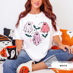 T-shirt with a heart-shaped design featuring three ghosts in pink and white with bats and stars.