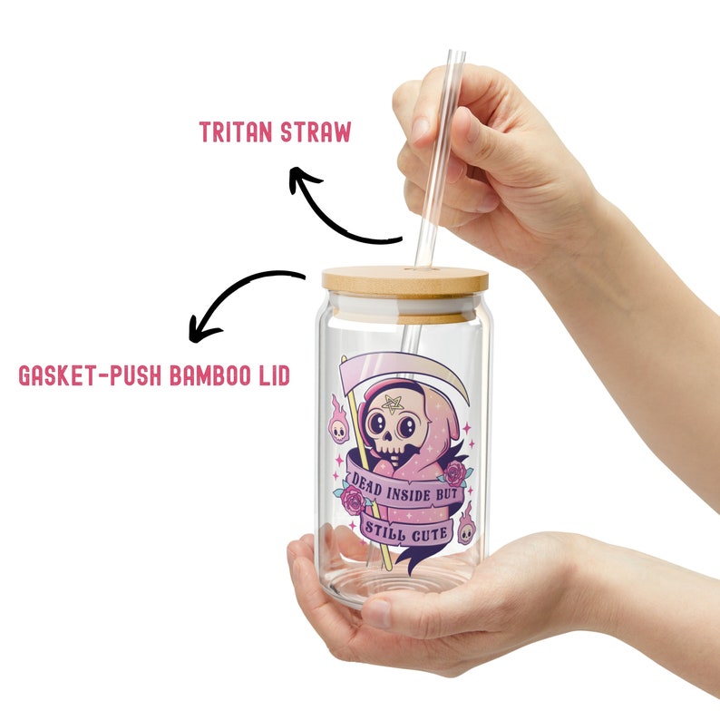 A clear glass can-shaped tumbler with a bamboo lid and Tritan straw. The tumbler features a cute Grim Reaper graphic with the text "DEAD INSIDE BUT STILL CUTE". The lid is a gasket-push bamboo lid.