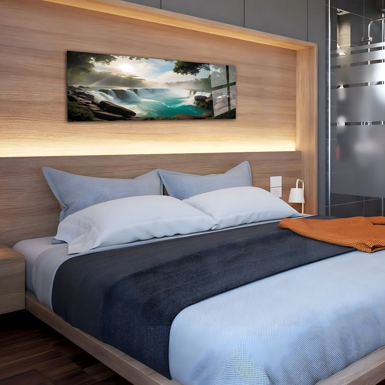 May include: A bedroom with a wooden headboard and a bed with blue and white bedding. A large framed print of a waterfall hangs above the bed.