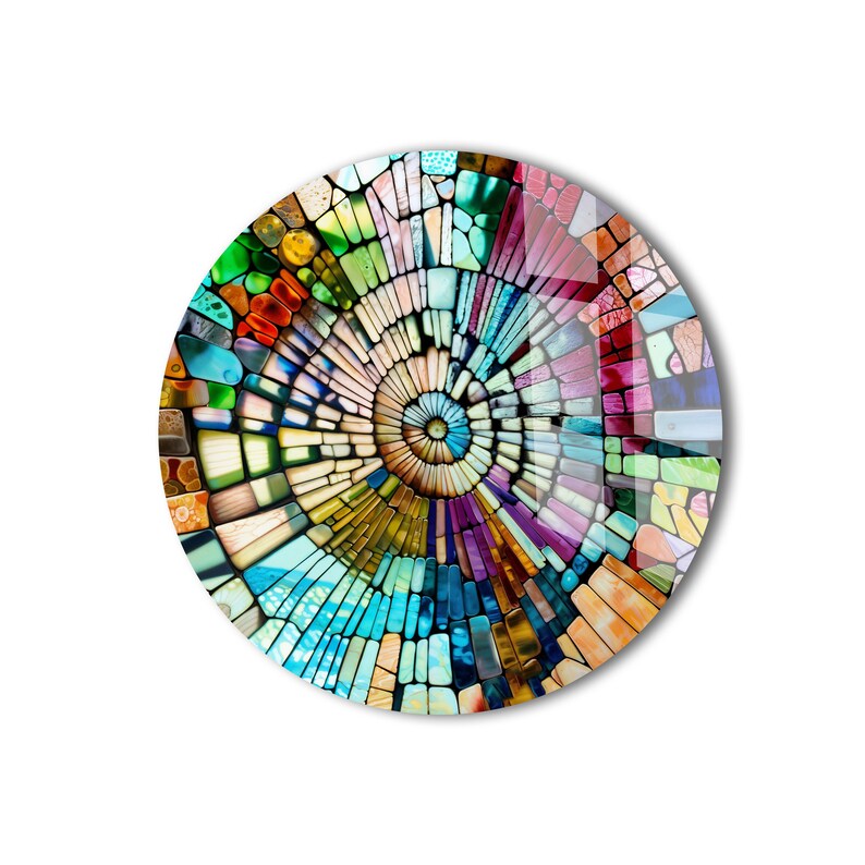 Op de afbeelding: Een kleurrijk cirkelvormig moza&iuml;ekontwerp met een spiraalpatroon in het midden. De moza&iuml;ek is gemaakt van kleine, onregelmatige stukjes glas in tinten blauw, groen, geel, oranje, rood en paars.