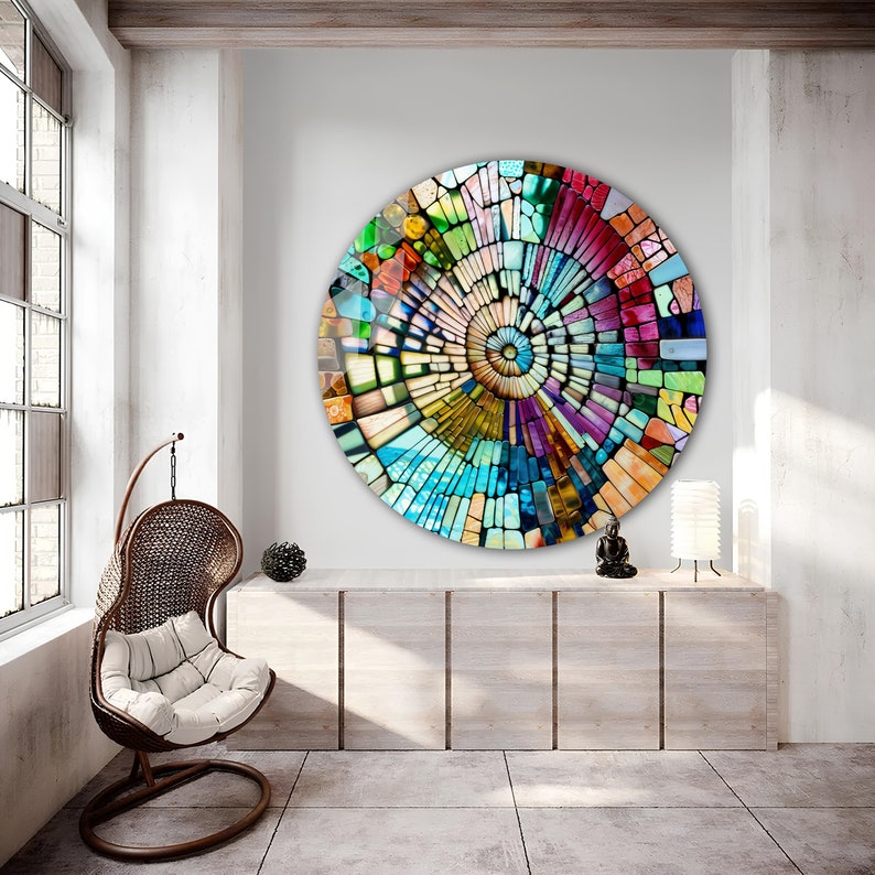Op de afbeelding: Een kleurrijke ronde moza&iuml;ek wandkunst met een spiraalvormig patroon in tinten blauw, groen, rood, geel en paars.