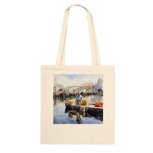 Puede incluir: Bolso tote de color crema con una pintura de acuarela de un hombre en un bote en un puerto. La pintura representa un día soleado con edificios, muelles y barcos. El hombre está rodeado de cajas de madera y el agua refleja el cielo.