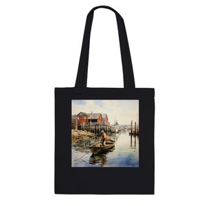 Puede incluir: Bolso tote negro con una pintura de acuarela de una escena costera. La obra de arte representa a una persona en un bote, edificios rojos y un puerto tranquilo. El bolso tiene dos asas negras.