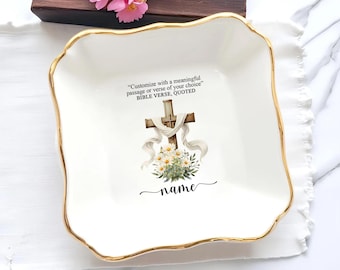 May include: A white ceramic square dish with a gold rim and a decorative cross design. The dish features the text "Customize with a meaningful passage or verse of your choice" and "BIBLE VERSE, QUOTED". The word "name" is also included.