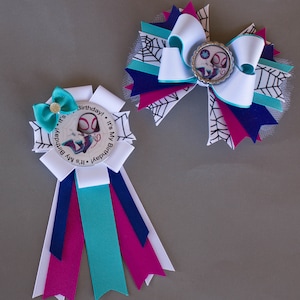 Puede incluir: Dos lazos de cumplea&ntilde;os hechos a mano con tem&aacute;tica de superh&eacute;roes. Uno es una roseta con cintas blancas, turquesas, azul marino y magenta. El otro es un lazo grande con cintas blancas, turquesas, azul marino y magenta, y un dise&ntilde;o de telara&ntilde;a.