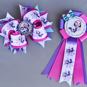 May include: Two handmade Spider-Gwen themed hair bows and a rosette. The large bow features a Spider-Gwen image and web design on white ribbon with pink, purple, and teal accents. The rosette has a "It's My Birthday!" message.