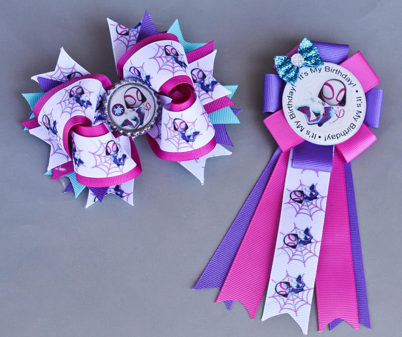 May include: Two handmade Spider-Gwen themed hair bows and a rosette. The large bow features a Spider-Gwen image and web design on white ribbon with pink, purple, and teal accents. The rosette has a "It's My Birthday!" message.