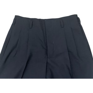 May include: A pair of black pleated pants with a front zipper and button closure.