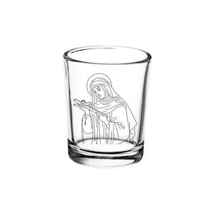 Puede incluir: Un vaso de chupito de vidrio transparente con un dibujo en blanco y negro de una mujer sosteniendo una cruz.