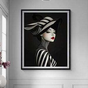 May include: A framed wall art print featuring a stylized illustration of a person wearing a wide-brimmed black and white striped hat and a matching striped garment. The figure has pale skin, closed eyes, and vibrant red lips against a dark background.