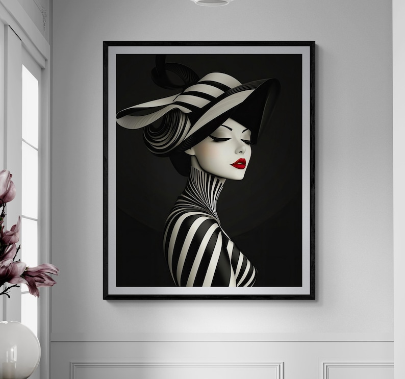 May include: A framed wall art print featuring a stylized illustration of a person wearing a wide-brimmed black and white striped hat and a matching striped garment. The figure has pale skin, closed eyes, and vibrant red lips against a dark background.