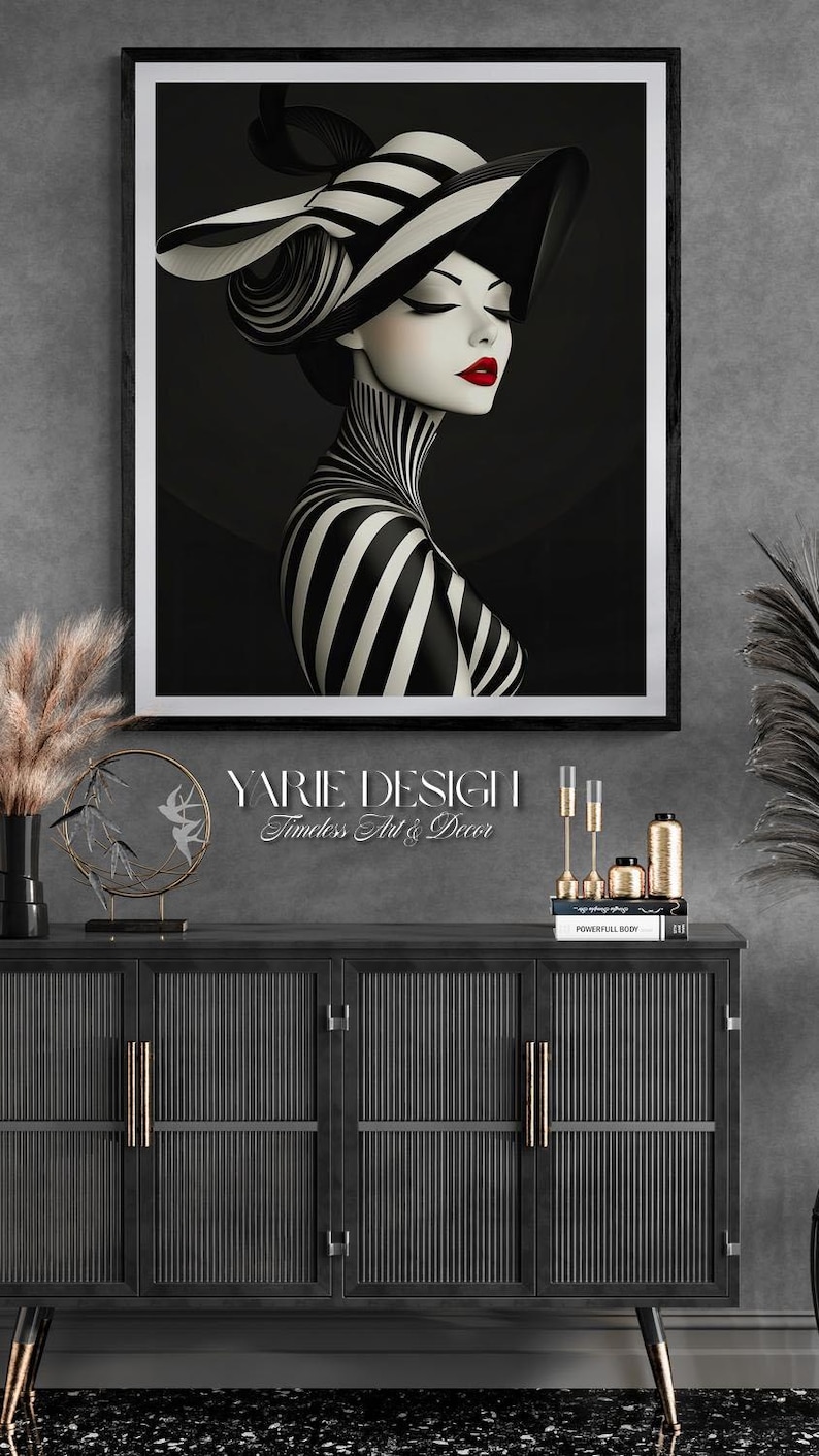 May include: A framed wall art print featuring a stylized illustration of a person wearing a wide-brimmed hat with black and white stripes, a matching striped high-neck garment, and bold red lipstick, set against a solid black background.