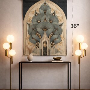 May include: A decorative wall tapestry, 26 inches wide and 36 inches tall, featuring a stylized floral design in shades of blue, gold, and beige. The tapestry hangs above a black console table, flanked by two gold floor lamps with globe lights.