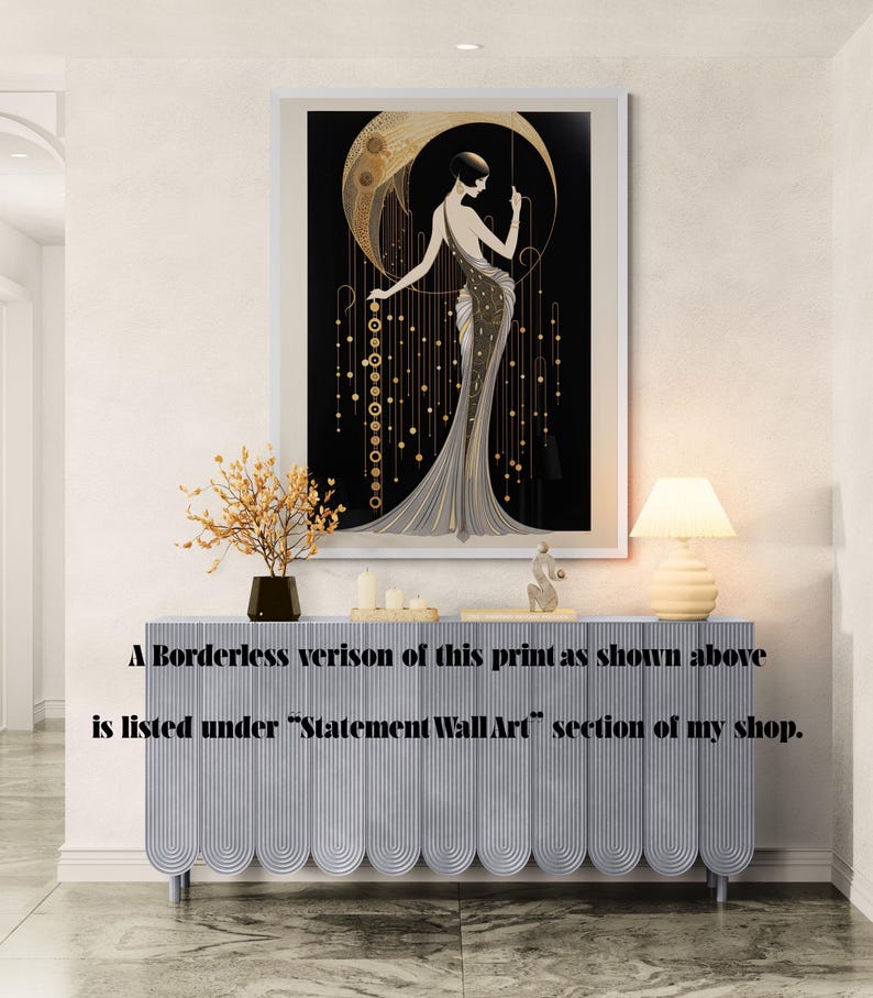 May include: A framed wall art print featuring a stylised figure in a long gown standing before a large golden crescent moon against a black background, with hanging gold circular accents and vertical lines, displayed above a light blue sideboard.
