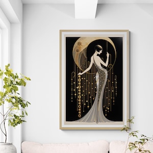 May include: A framed wall art print featuring a stylised figure in a long, flowing gown standing before a large golden crescent moon. The design incorporates black, gold, and cream tones with intricate geometric patterns and hanging circular accents.