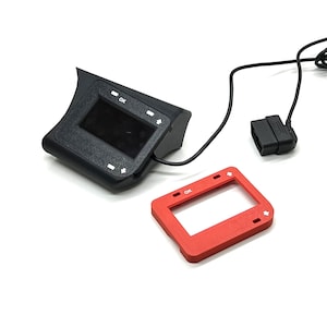 May include: A black electronic device with a small screen, arrows, and the word "OK" is connected to a black cable and a red frame. The device is likely for automotive diagnostics or performance monitoring.