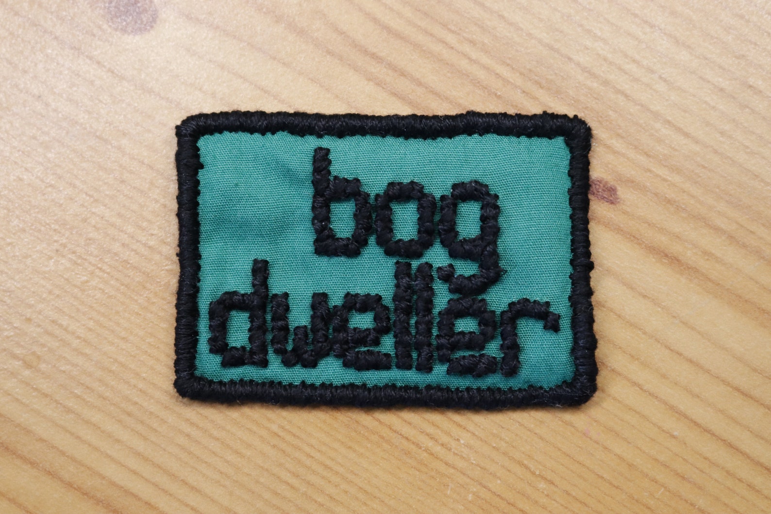 Bog Dweller cross-stitched patch in green and black