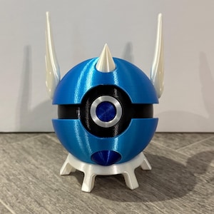 May include: A blue and white 3D printed figurine of a Pokemon. The Pokemon is a blue sphere with a black ring around the middle and a white spike on top. The Pokemon has two white horns on the side. The Pokemon is standing on a white base with three legs.