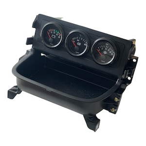 Puede incluir: Un panel de instrumentos de tablero automotriz negro con tres indicadores analógicos VDO circulares. El indicador izquierdo muestra el voltaje de la batería, el central muestra la temperatura en grados Celsius y el derecho indica la presión en bares.