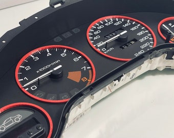 May include: A black car dashboard with red accents. The dashboard features a speedometer, tachometer, and other gauges. The speedometer reads up to 240 km/h and the tachometer reads up to 8,000 rpm.